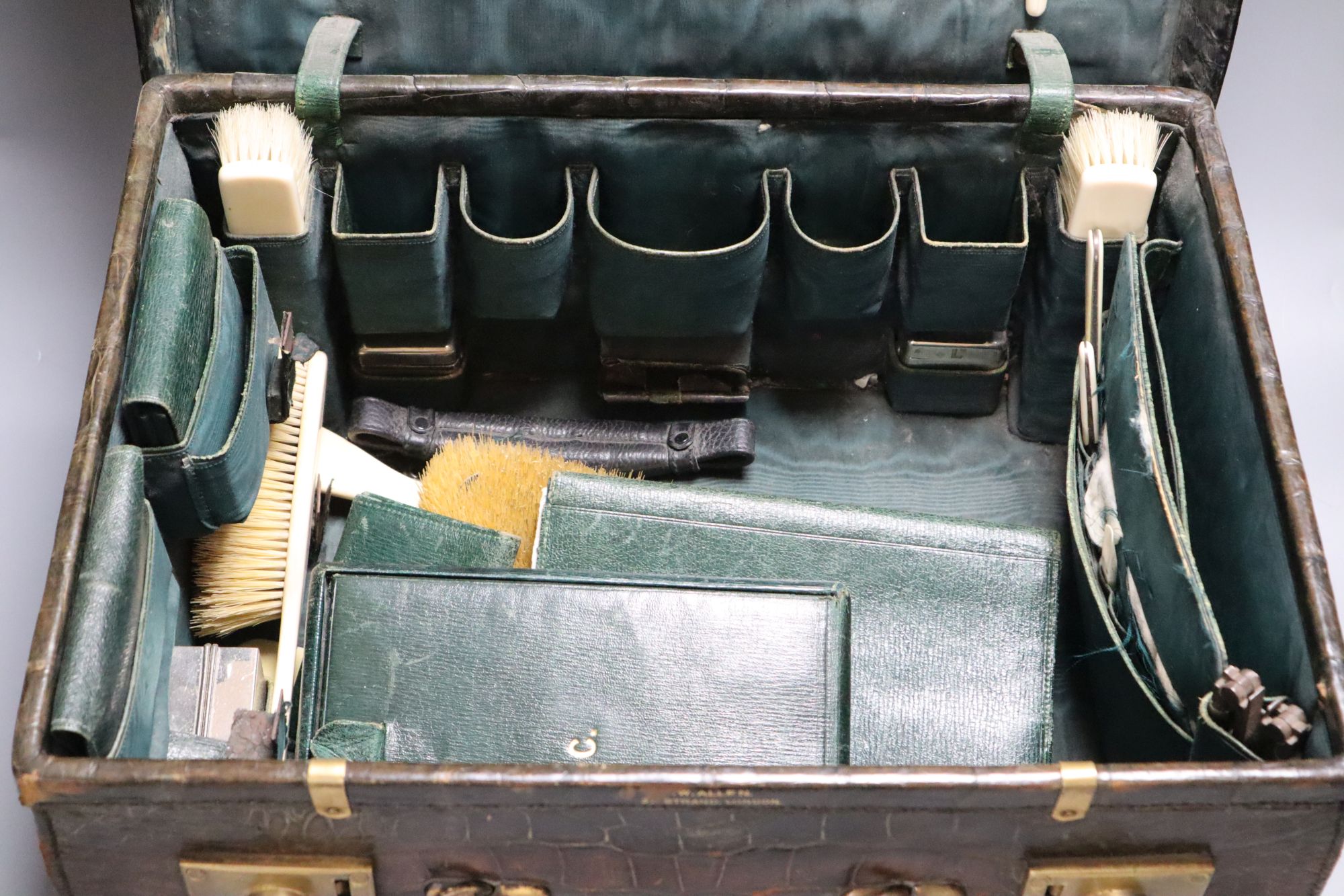 A crocodile skin travelling toilet case and contents